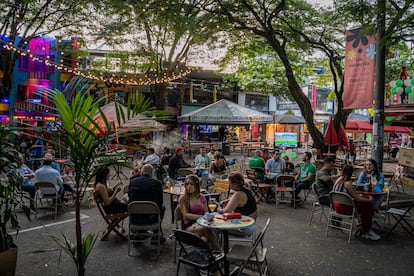 Varias personas comparten en sillas al aire libre en el sector de Provenza, en Medellín.