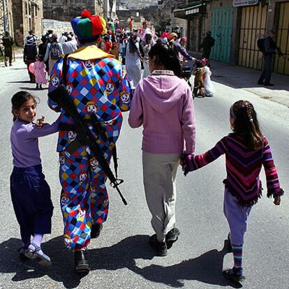 Un colono, disfrazado de payaso, celebra con su familia la fiesta judía de Purim ayer en Hebrón.