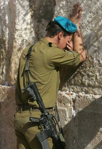 Un soldado israelí reza por Sharon ante el Muro de las Lamentaciones.