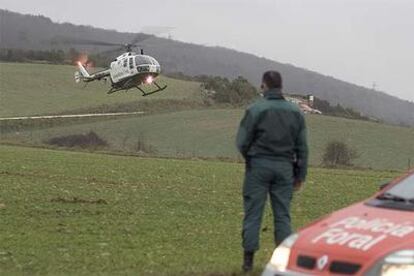 Un guardia civil observa uno de los helicópteros que participaron en las labores de rescate.