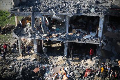 Ciudadanos palestinos observan la destrucción de un edificio tras un bombardeo israelí, en Rafah, al sur de la Franja de Gaza. 