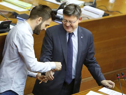 El diputado Fran Ferri coloca una pulsera reivindicativa LGTB al presidente Ximo Puig.