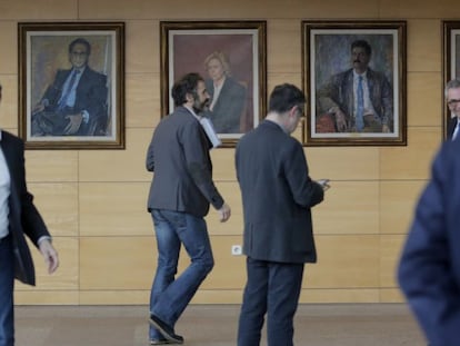 A la izquerda, el retrato de Ramón Espinar en la Asamblea de Madrid.