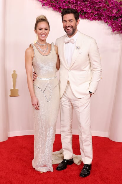 Emily Blunt, nominada como mejor actriz de reparto por 'Oppenheimer', junto a su marido, John Krasinski. La pareja ha coordinado sus estilismos blancos. Blunt ha lucido un vestido de Schiaparelli y joyas de Tiffany & Co. 