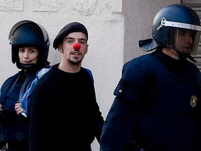 Uno de los jóvenes ocupantes de Can Ricart abandona el recinto fabril, ayer, acompañado por un <i>mosso d&#39;esquadra.</i>