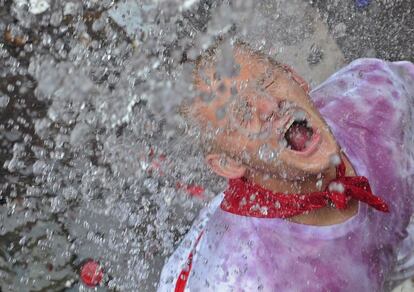 Un joven reacciona mientras le rocían con agua durante el chupinazo en 2009.