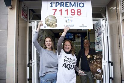 La administradora de la administracion de loteria 'La Biznaga', Catalina Duran (c), celebra junto a clientes y empleados el haber vendido 32 series del gordo de la lotería de navidad, el 71198, que suman 128 millones de euros. 
