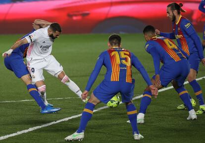 El delantero francés del Real Madrid Karim Benzema intenta un lanzamiento ante varios rivales del Barcelona.