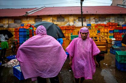 Dos hombres trabajaban este martes en un mercado de pescado en Kochi (India). El Departamento Meteorológico del país prevé que el monzón del suroeste llegue a la costa sur del país antes de lo normal este año. 