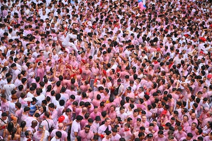 Centinaia di persone vestite di bianco e rosso si godono l'atmosfera festosa nella Piazza del Municipio di Pamplona questa domenica.