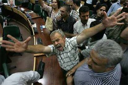 Un palestino exige a gritos su salario junto a decenas de funcionarios que ayer irrumpieron en una sesión del Parlamento en Ramala.