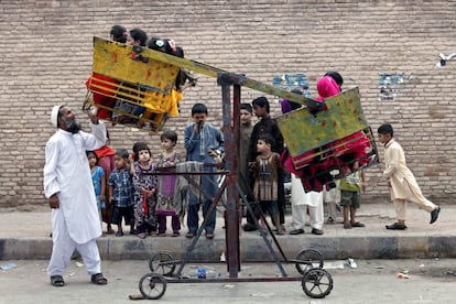 Niños musulmanes se divierten en un rudimentario columpio durante la celebración del Eid al-Fitr en Peshawar, Pakistán.