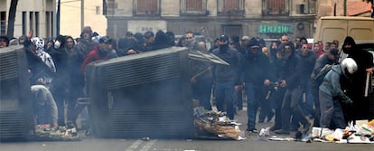 El grupo de antisistemas lanza objetos detrás de unas barricadas