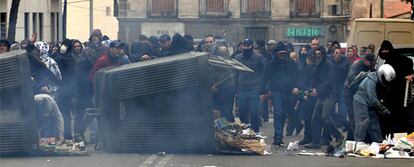 El grupo de antisistemas lanza objetos detrás de unas barricadas