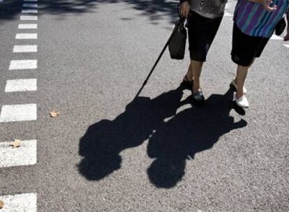 Una pareja de ancianas pasea por una calle de Barcelona en un día de verano.