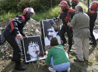 La Ertzaintza retira las fotos de dos de los etarras homenajeados ayer en Morlans (San Sebastián) en presencia de sus familiares.