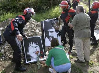 La Ertzaintza retira las fotos de dos de los etarras homenajeados ayer en Morlans (San Sebastián) en presencia de sus familiares.