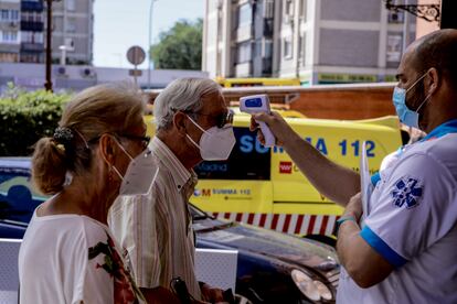 A healthcare worker takes a man's temperature in Villaverde, Madrid.