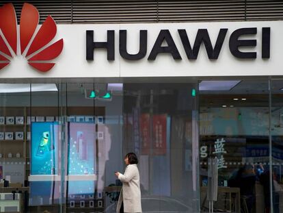 Una mujer pasa caminando por delante de un logo de Huawei el pasado diciembre en un centro comercial de Shangái (China).