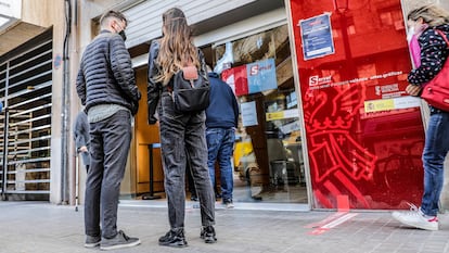 Varias personas esperan para entrar en una oficina del SEPE en Valencia.