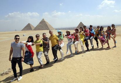 Un grupo de turistas posa para una foto ante las pirámides de Guiza, en Egipto.