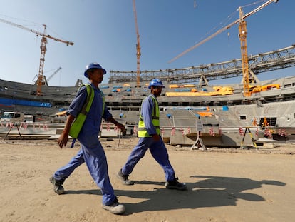 Dos trabajadores en el interior del estadio Lusail de Doha, Qatar, en diciembre de 2019. El recinto se ha construido para el campeonato mundial de fútbol de 2022, que se celebrará en esta ciudad.