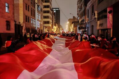 Seguidores de Pedro Castillo cargan una bandera gigante de Perú en las calles de Lima