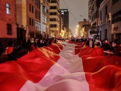 Una bandera de Perú sostenida por seguidores del candidato Pedro Castillo en el centro de Lima, este lunes.