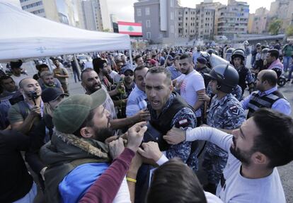 Los antidisturbios tuvieron que enfrentarse el viernes a varias decenas de jóvenes que se decían seguidores de Hezbolá —partido en la coalición mayoritaria del Gobierno— a pesar de que en un discurso televisado su líder, Hasán Nasralá, llamó a los jóvenes a “no participar ni interferir en las manifestaciones” para evitar que su presencia “fuera politizada”. En la foto, un policía antidisturbios libanés arresta a un manifestante durante los enfrentamientos entre partidarios de Hezbolá y manifestantes antigubernamentales en Beirut, Líbano.