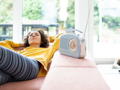 Una mujer escucha tumbada la radio.