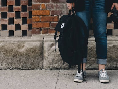 Una adolescente sujeta su mochila para ir a clase.