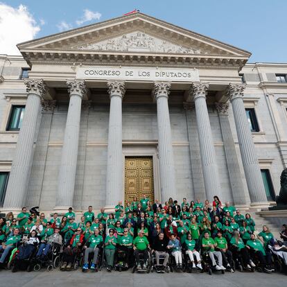 MADRID, 10/10/2024.- Juan Carlos Unzué (c, con jersey negro), exfutbolista, exentrenador y enfermo del ELA, celebra junto a pacientes de ELA y sus familiares la aprobación de la ley ELA este jueves en el exterior del Congreso de los Diputados en Madrid. EFE/ Sergio Pérez