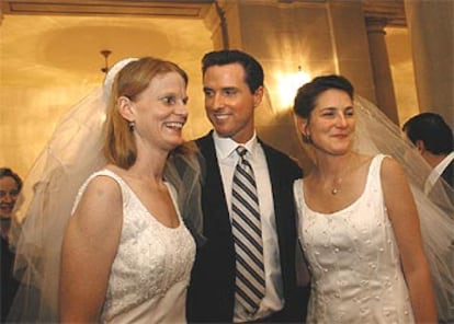 El alcalde de San Francisco, Gavin Newsom, posa junto a una pareja de lesbianas en una recepción en el Ayuntamiento.