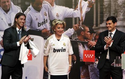 La presidenta de la Comunidad posa con la camiseta del equipo blanco ante la mirada de Sergio Ramos y Casillas