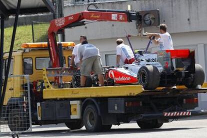 Los operarios retiran el bólido de Lewis Hamilton.