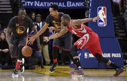 El jugador de los Golden State Warriors Shaun Livingston (centro) lucha por el balón con Marcus Thornton (derecha) y Draymond Green de los Houston Rockets.