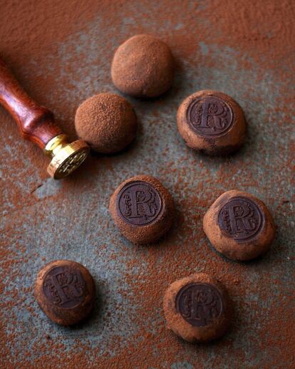 <p><b>Ingredientes</b> (para 24 trufas)</p><p>250 gramos de chocolate negro de cobertura troceado (de 55% a 70% de cacao), 200 mililitros de nata para montar, 50 gramos de mantequilla, 1 pizca de sal, cacao puro en polvo para espolvorear.</p><p><b>Preparación</b></p><p> En un cazo al fuego, calentar la nata con la sal. Cuando esté caliente, retirar del fuego, agregar el chocolate troceado y remover hasta que esté disuelto. Añadir por último la mantequilla, mezclar hasta integrar y dejar enfriar la mezcla (primero a temperatura ambiente y luego en el frigorífico en un recipiente hermético, hasta que se le pueda dar forma con las manos). Una vez fría la masa, sacar porciones y darles forma de bolita con las manos. Espolvorear con cacao y mantener en el frigorífico hasta el momento de consumir. Para decorar las trufas se ha usado un sello de lacre metálico. Para ello, hay que introducir tanto la trufa como el sello en el congelador: cuando estén congelados, pasar la trufa por cacao y presionar con el sello para que quede la forma grabada. Las trufas pueden aromatizarse con especias como canela, cardamomo o pimienta, o añadirles un par de cucharadas de licor al gusto.</p>