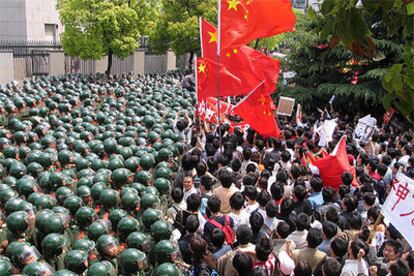 Policías antidisturbios protegen el consulado de Japón en Shanghai de los manifestantes, que portan banderas chinas.