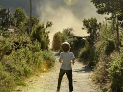 Un niño observa la llegada de un helicóptero para luchar contra el incendio de Chandrexa de Queixa