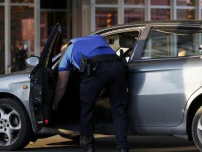 Oficiales de polic&iacute;a de Ginebra requisan un coche este viernes en el aeropuerto Cointrin tras elevar el nivel de alerta de ataques terroristas.