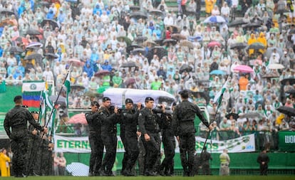 Militares carregam os caix&otilde;es diante da torcida da Chapecoense.