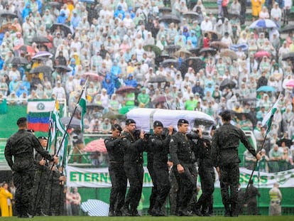 Militares carregam os caix&otilde;es diante da torcida da Chapecoense.