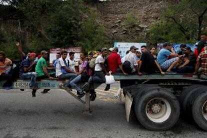 Migrantes hondureños suben a camiones para ir a la Ciudad de Guatemala