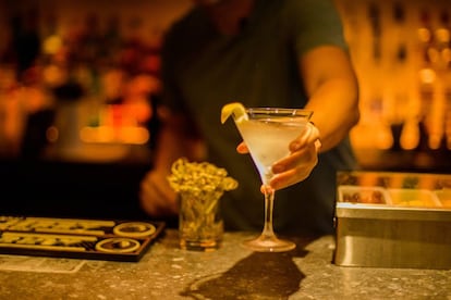 Un camarero sirve una copa en el interior de una discoteca.