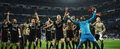 Jugadores del Ajax celebran la victoria anoche en el Bernabeu.