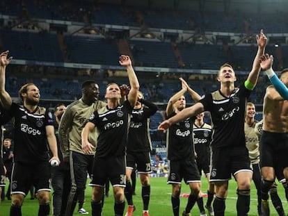 Jugadores del Ajax celebran la victoria anoche en el Bernabeu.