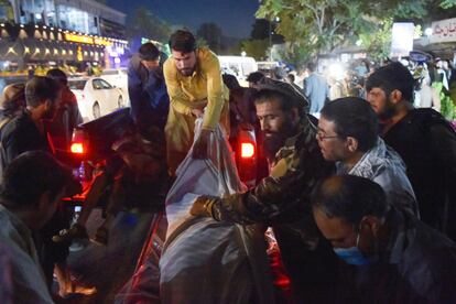 Un terrorista suicida se ha hecho estallar entre la multitud concentrada en los alrededores del aeródromo mientras un segundo artefacto explotaba en un hotel cercano. En la imagen, voluntarios y personal sanitario trasladan a varios heridos a un hospital de Kabul, este jueves.