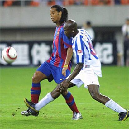 Ronaldinho supera la acometida de Kola.