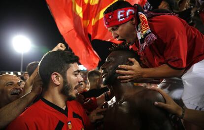 Aficionados mallorquinistas celebran el ascenso junto al delantero Lago Junior.