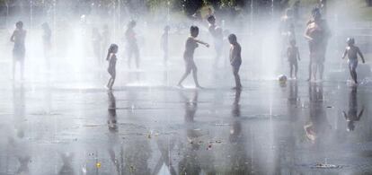 Un grupo de niños se refresa en la 'playa' de Madrid Río.